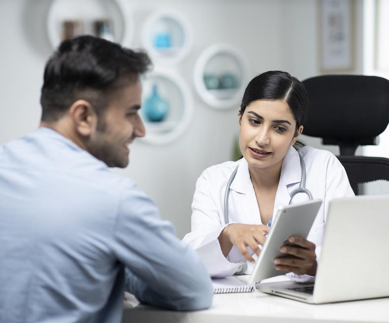 uses laptop while talking with patient stock photo